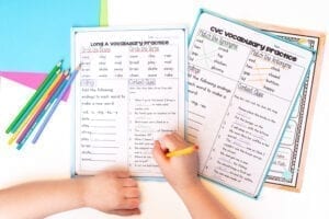 Child using spelling worksheets with colored pencils.