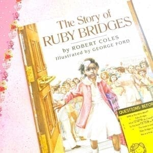 Cover of Ask and Answer Mentor Text The Story of Ruby Bridges showing image of young Ruby Bridges walking through a door and a sticky note with questions on the bottom right side of book.