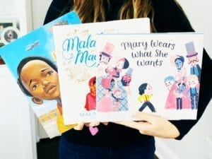 Teacher holding three mentor texts focused on character traits and character education, including book titled Mary Wears What She Wants.