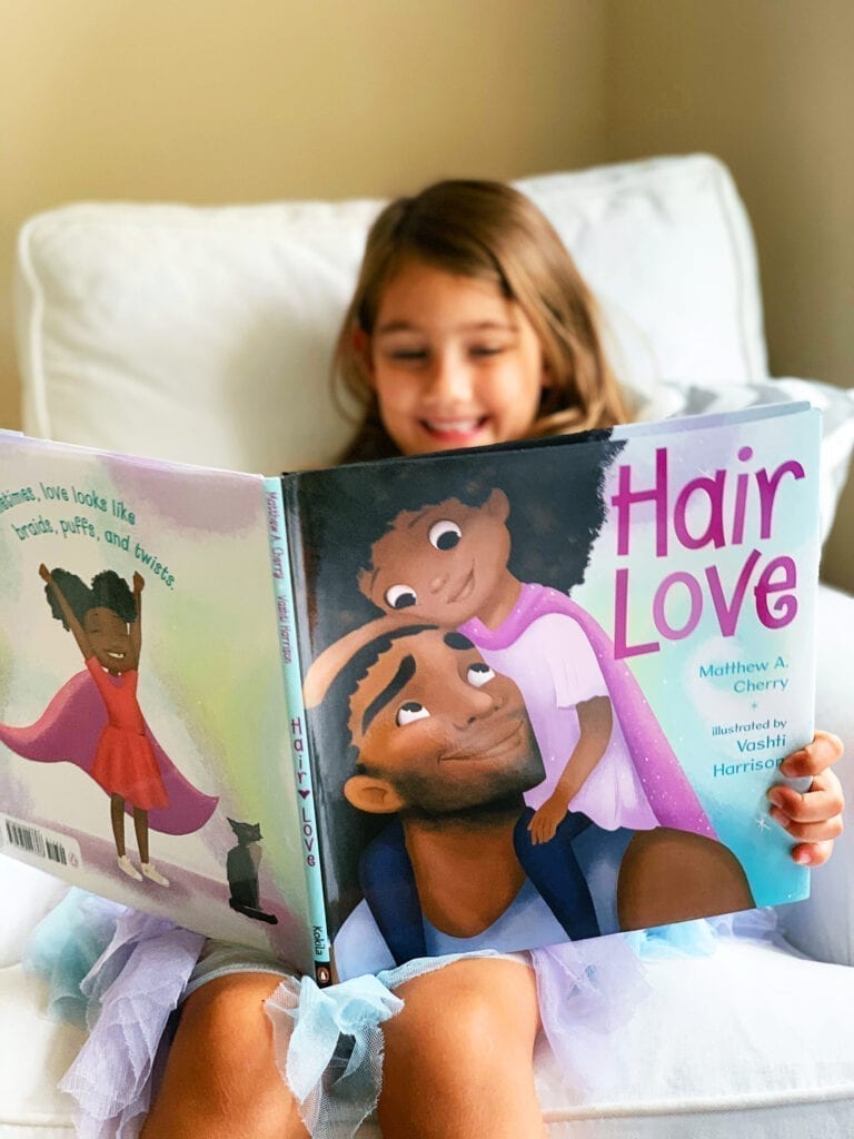 Girl reading Hair Love mentor text